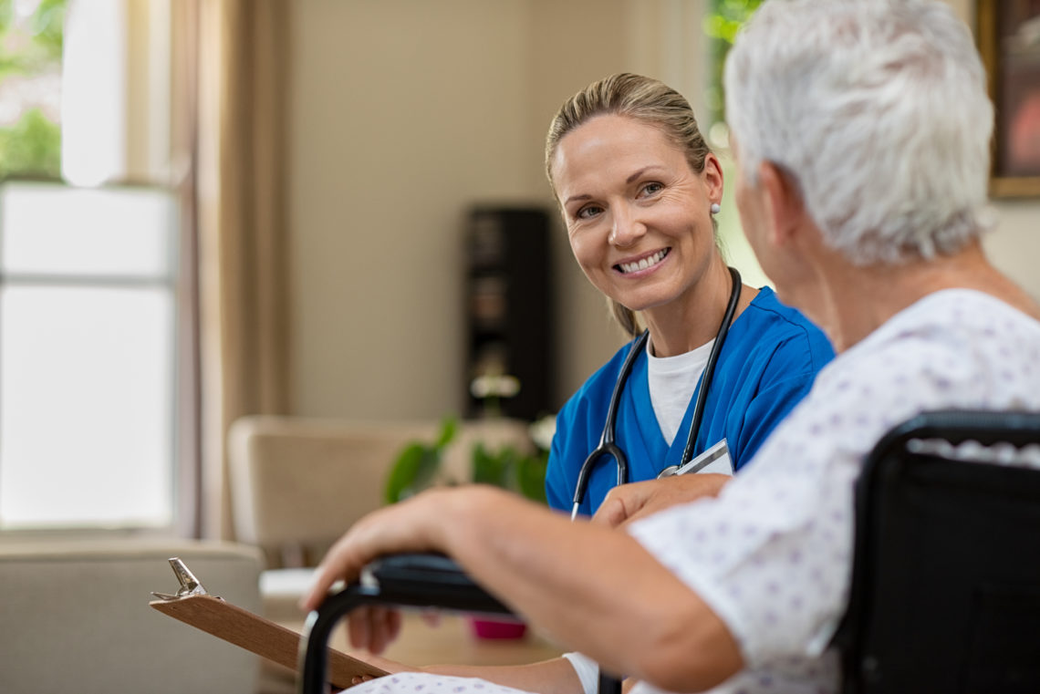 Friendly nurse talking to senior patient