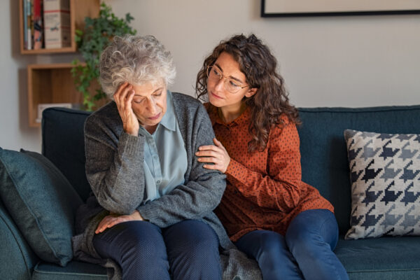 Young woman consoling upset grandmother